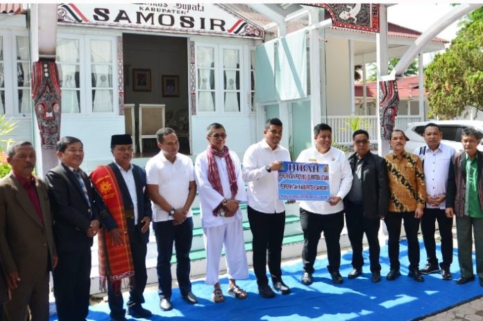 Teks Foto : Gubernur Sumatera Utara (Sumut) Muhammad Bobby Afif Nasution menyerahkan aset Pemerintah Provinsi (Pemprov) kepada Bupati Kabupaten Samosir Vandiko Gultom berupa bangunan yang selama 21 tahun digunakan sebagai Rumah Dinas Bupati, di Pangururan, Samosir, Minggu (6/7/2025). (Alian/Rel) 