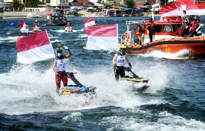 Teks Foto :  Kemeriahan Peringatan HUT ke 80 Kemerdekaan Republik Indonesia di Venue Aquabike Jetski World Championship 2025, Balige, Kabupaten Toba, Minggu (17/08/2025). Selain Upacara Pengibaran Bendera Merah Putih, digelar juga Parade Lap dengan mengibarkan 17 Bendera Merah Putih oleh Pebalap dari berbagai negara yang ikut bertanding dalam event ini. (Foto : Ist)