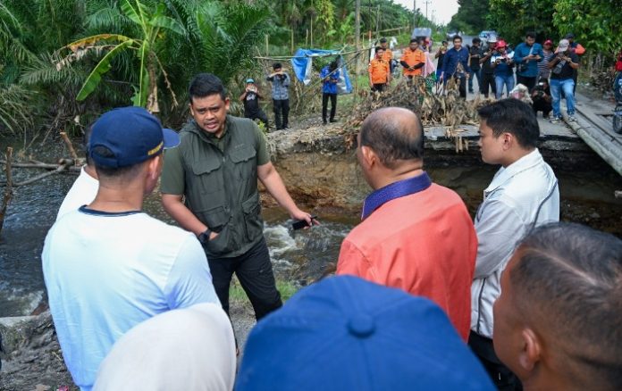 Teks Foto : Gubernur Sumut, Bobby Nasution meninjau ruas jalan putus di Kecamatan Padangtualang, Kabupaten Langkat, Jum'at (5/12/2025). Ruas jalan tersebut merupakan jalur alternatif masyarakat Padangtualang menuju Stabat dan Tanjungpura. (Foto : Ist) 