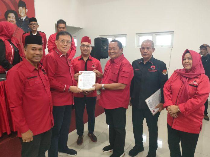 Teks Foto : Ketua DPD PDI Perjuangan Provinsi Sumatera Utara, Drs. Rapidin Simbolon, MM, secara resmi menyerahkan Surat Keputusan (SK) Kepengurusan DPC PDI Perjuangan Kota Medan periode 2025-2030. Penyerahan SK tersebut dilaksanakan dengan khidmat di Kantor DPD Partai, Jalan Letjen Djamin Gintings, Medan, pada Sabtu (11/04/2026).