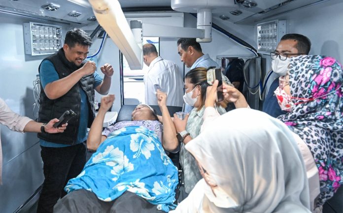 Teks Foto :  Gubernur Sumut Bobby Nasution bersama Ketua TP PKK Sumut Kahiyang Ayu mengunjungi Puskesmas Lagundri, Kabupaten Nias Selatan, Sabtu (18/07/2026). Gubernur Sumut juga mengunjungi pasien yang sedang ditangani di Bus Operasi Keliling Dinas Kesehatan Sumut. (Foto : Ist)